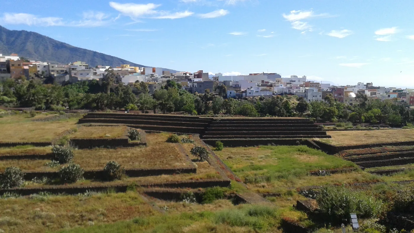 Stepped stone terraces of the Pirámides de Güímar with the town and mountains behind, Tenerife.