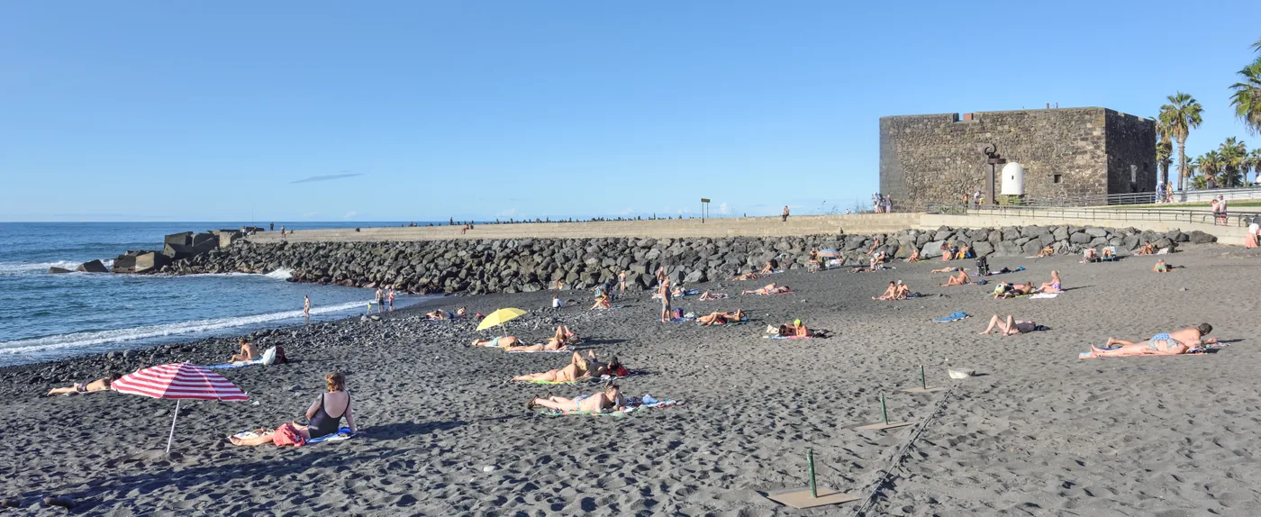 Playa Jardín’s black sand and the Castillo de San Felipe at Puerto de la Cruz, Tenerife.